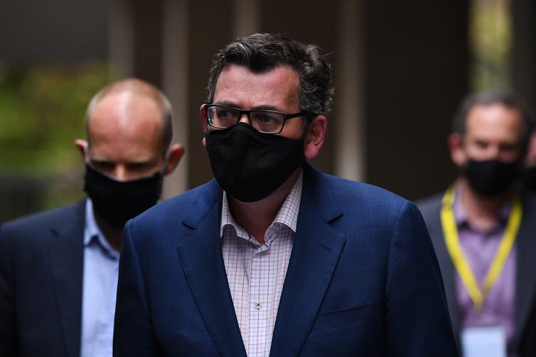 Premier Daniel Andrews walking with a mask on
