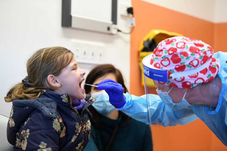 Young girls gets a coronavirus test in a clinic.