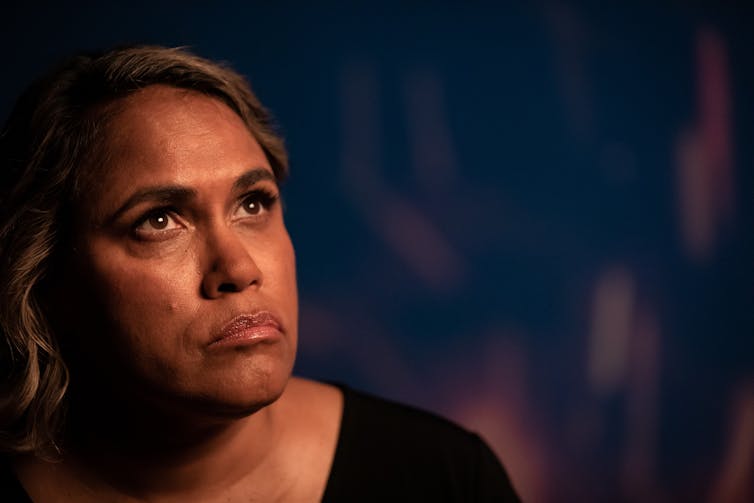 Indigenous woman looks pensive.