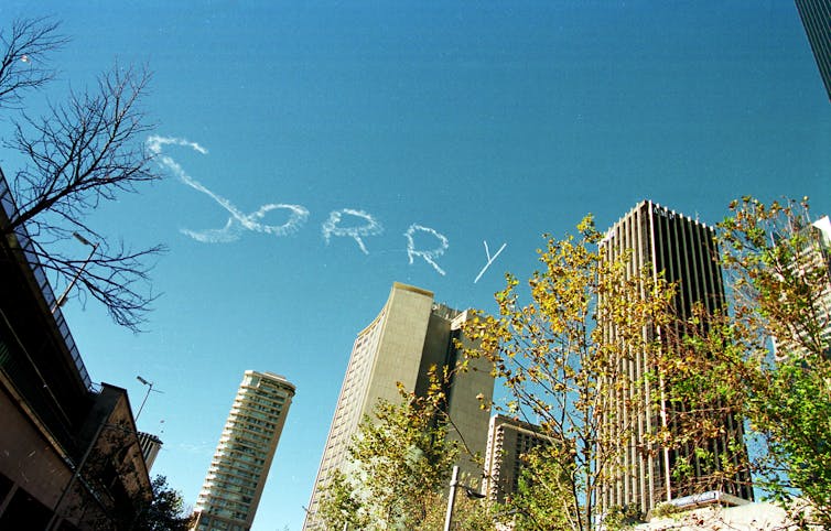 Sorry written in sky over Sydney office towers.