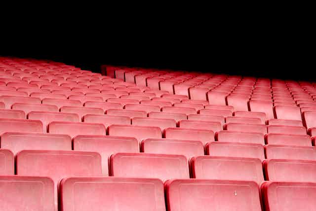 Empty red seats in an auditorium.