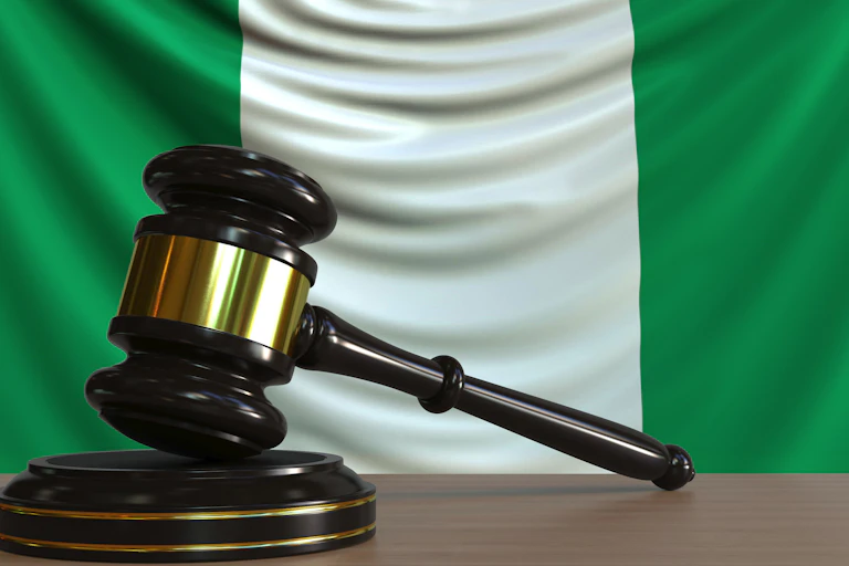 Judge's gavel and block against the flag of Nigeria