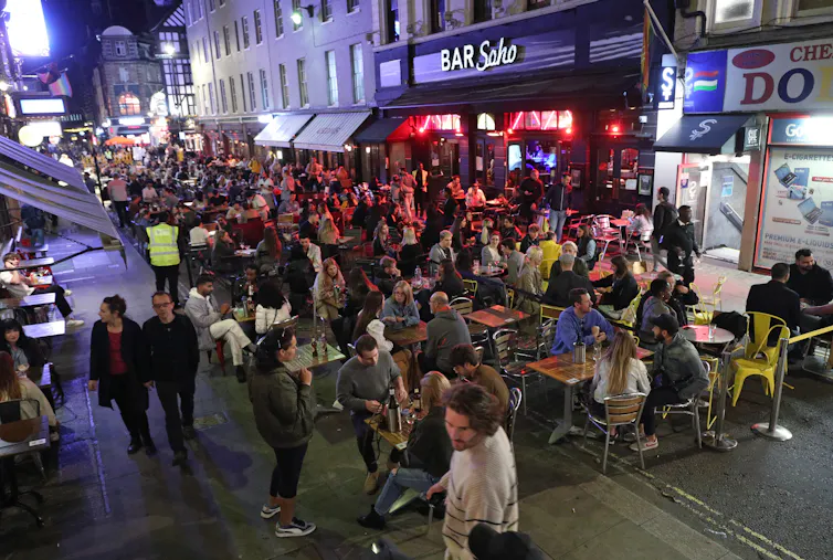 Busy outdoor restaurant area in Soho, London