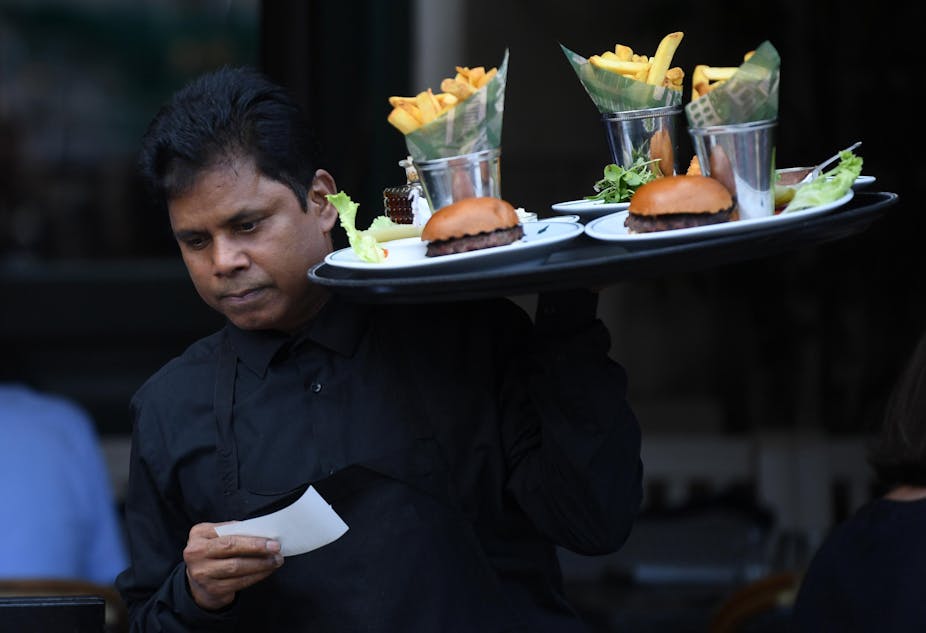 London waiter carrying tray with burgers and chips