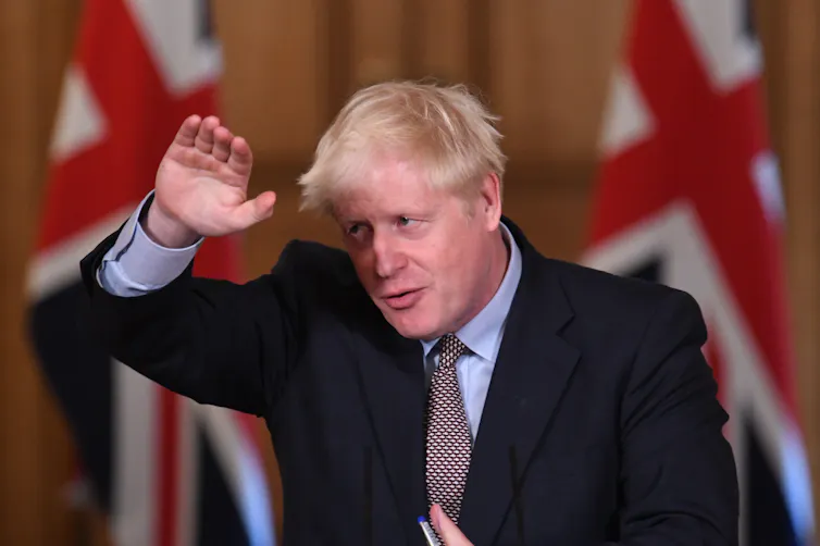 Boris Johnson gestures at a press conference.