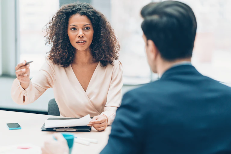 A woman is seen speaking at a table with a man.
