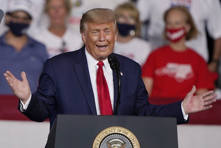 Trump gestures and makes a face while speaking to a crowd.