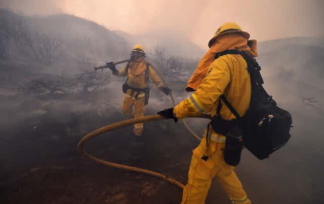 Firefighters walk through smoke during the fire at Lake Elsinore, California, in 2018.