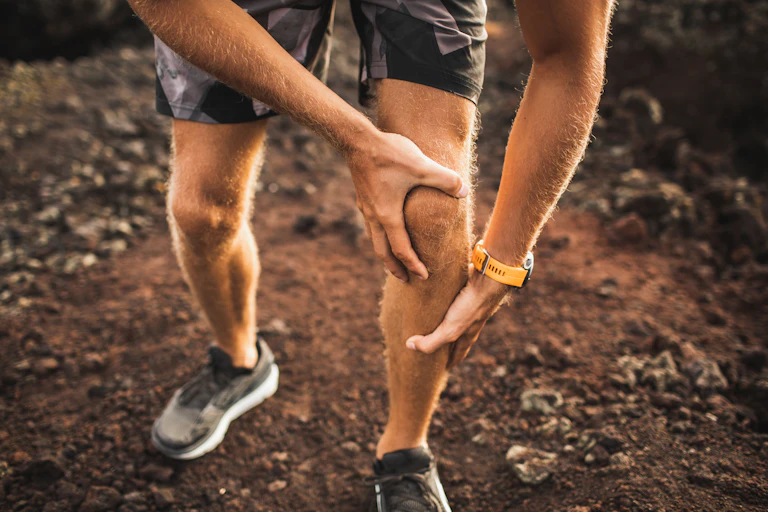 Runner holding his knee in pain