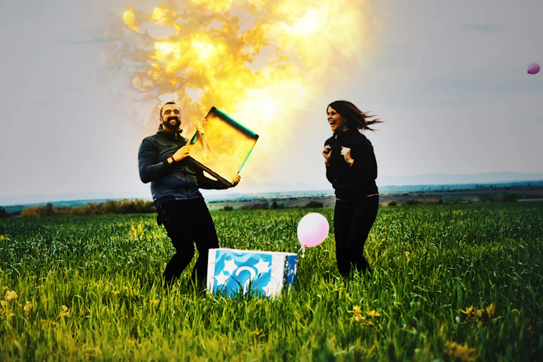 With his excited wife looking on, a man opens a box as a flame shoots out of it.