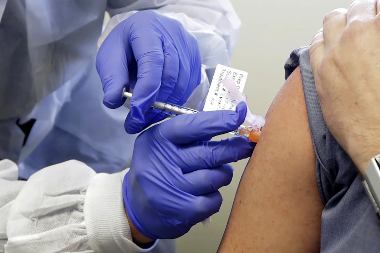 Neal Browning receives a shot in the first-stage safety study clinical trial of a potential vaccine for COVID-19 on March 16 at the Kaiser Permanente Washington Health Research Institute in Seattle.