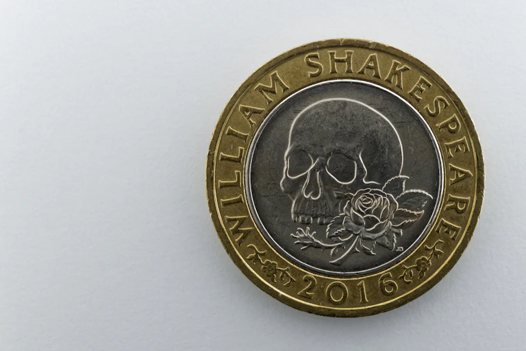 A coin showing a skull and rose.