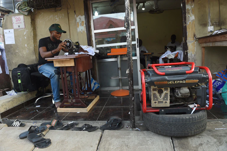 A tailor using a generator for power due to the epileptic public power supply in Lagos.