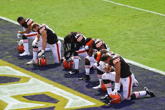 Cleveland Browns players kneel before the playing of the National Anthem.