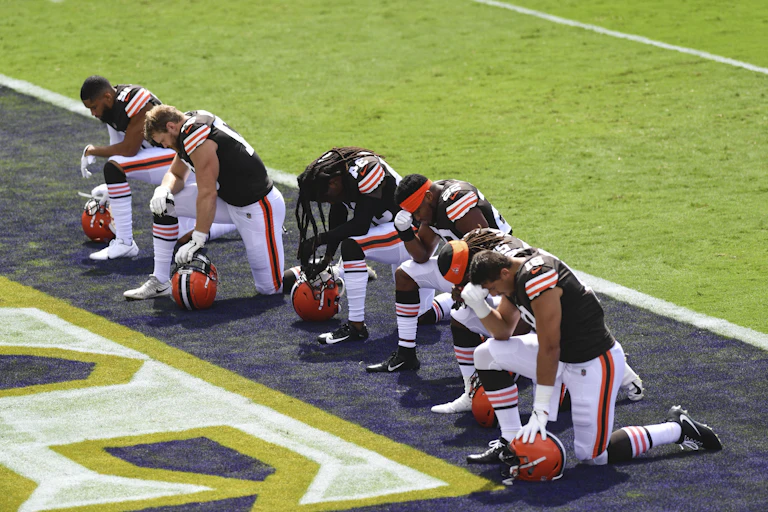 Cleveland Browns players kneel before the playing of the National Anthem.