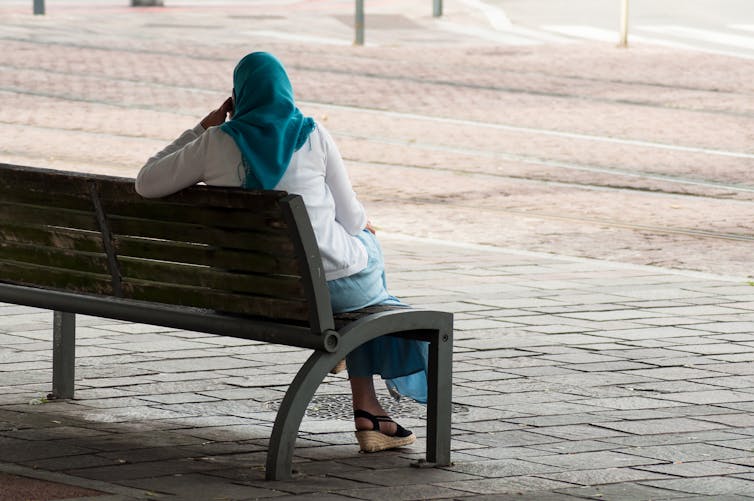 A woman sits on a bench.