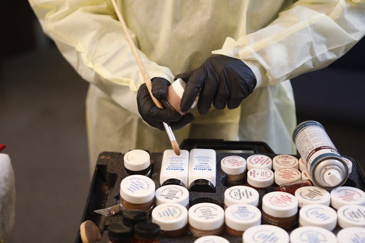 A funeral home worker handles cosmetics used to makeup the deceased.