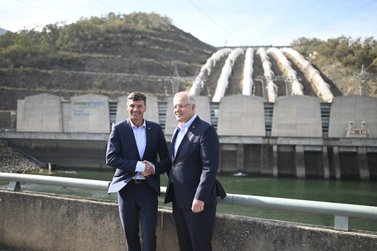 Scott Morrison and Angus Taylor shake hands in front of Snowy Hydro