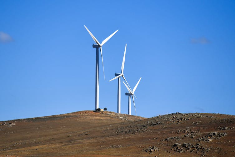 Wind turbines against a blue sky.