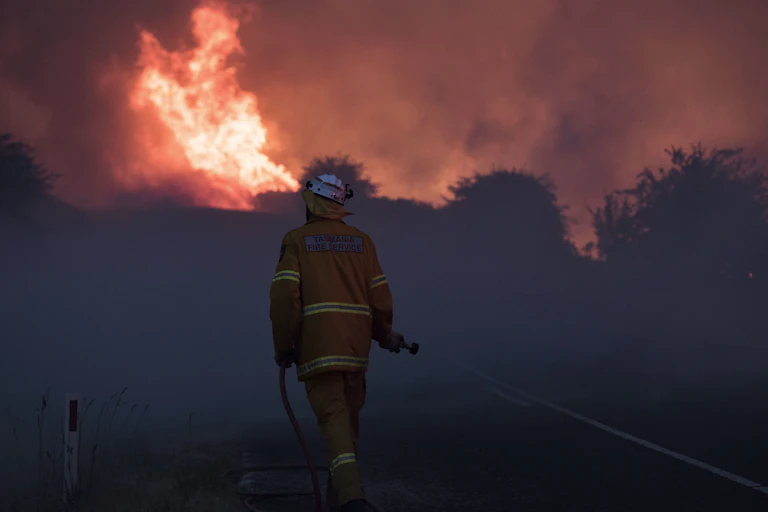 Firefighter moves towards a large blaze.