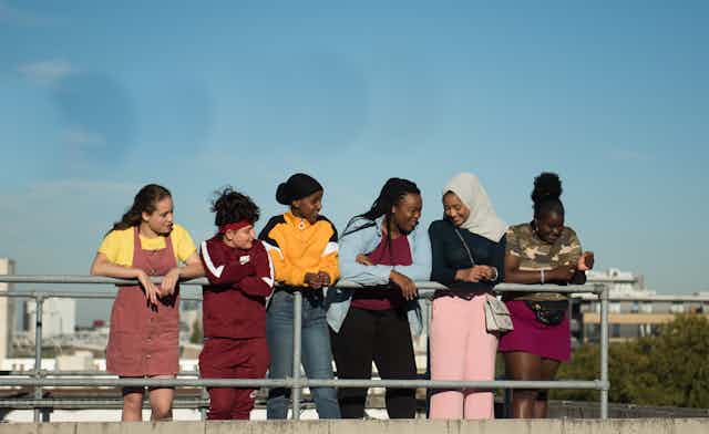 Group of girls look out on a city.