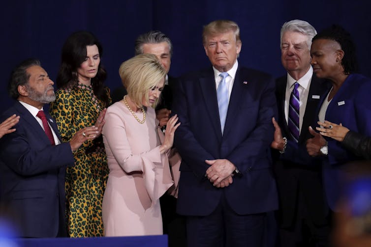 Trump is surrounded by evangelical Christians as they pray.