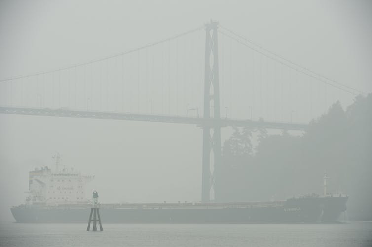 Une épaisse fumée remplit l'air autour d'un navire.