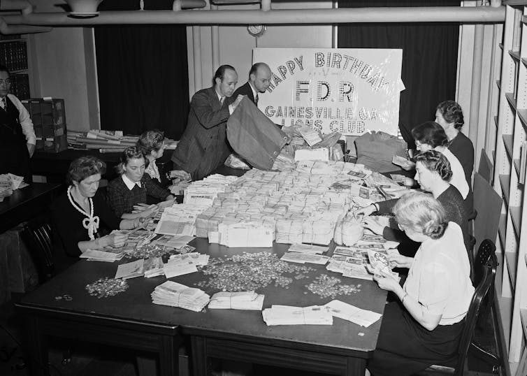 Staff sift through mail and makes piles of dimes in the 1940s.