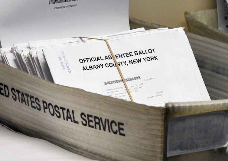 Mailed ballots sit in a box.