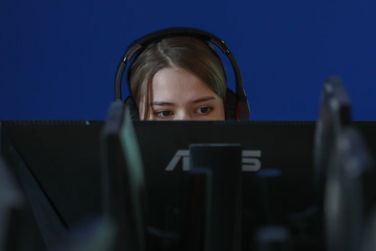 Teenager with headphones is looking at a screen