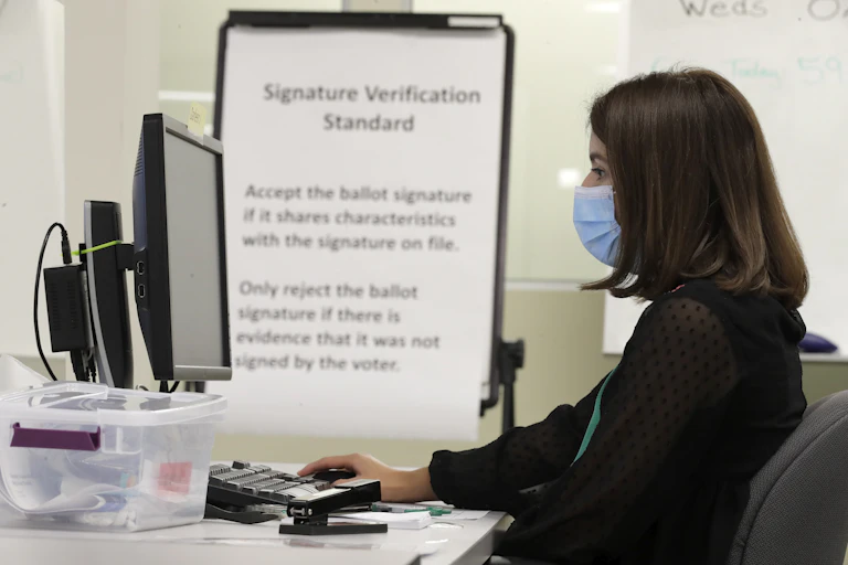 A woman sits at a computer.