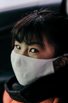 Girl wearing a white cloth face mask.