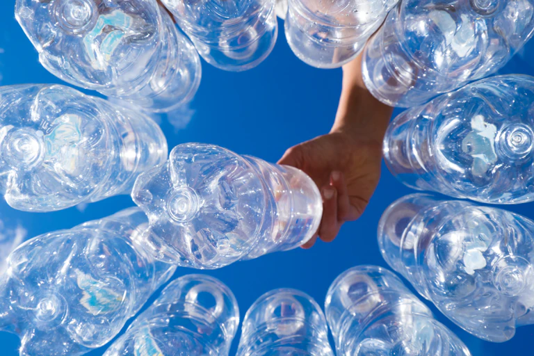 Hand picking up one of several plastic drink bottles