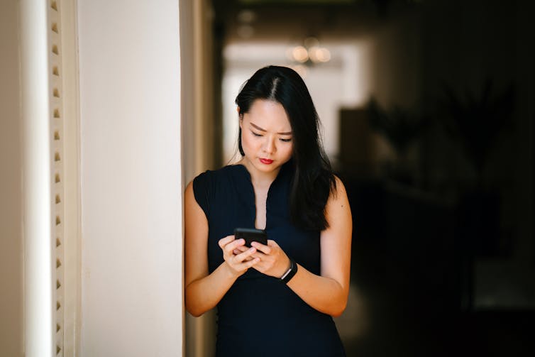 Woman looking at her phone with serious expression.