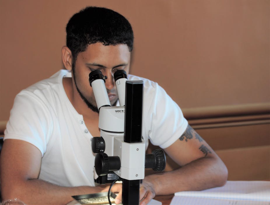A man looks through a microscope
