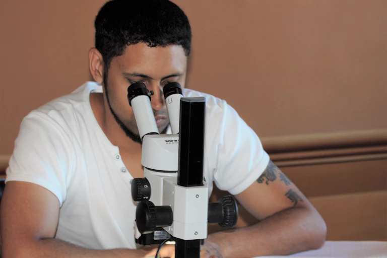 A man looks through a microscope