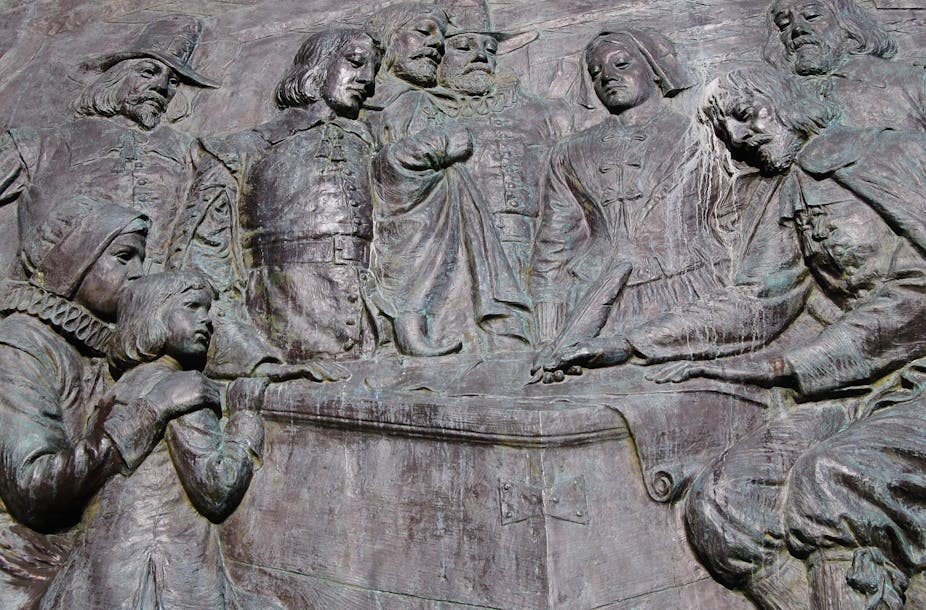 Sculpture of group of men and women signing a document.