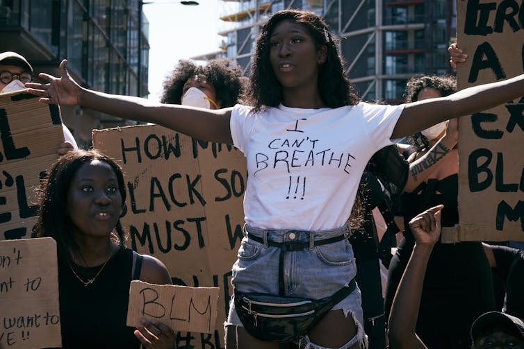 Black Lives Matters protesters holding signs and marching.