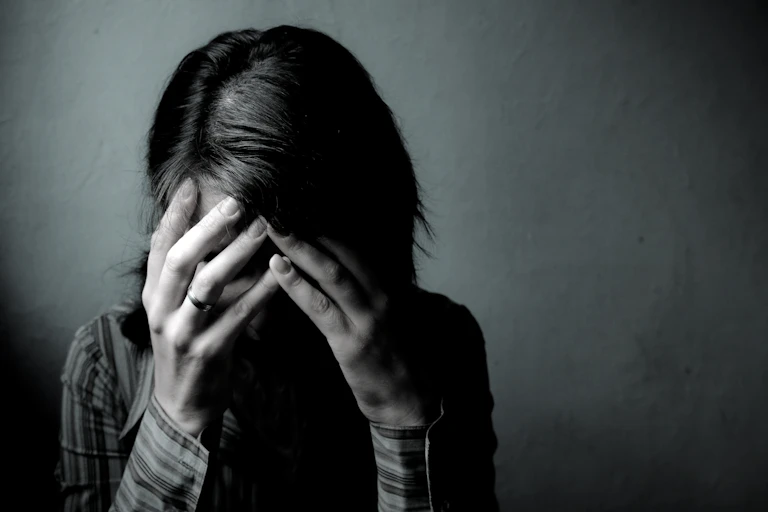 Despairing dark-haired woman with head in hands