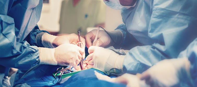 Surgeons performing surgery in an operating theatre.