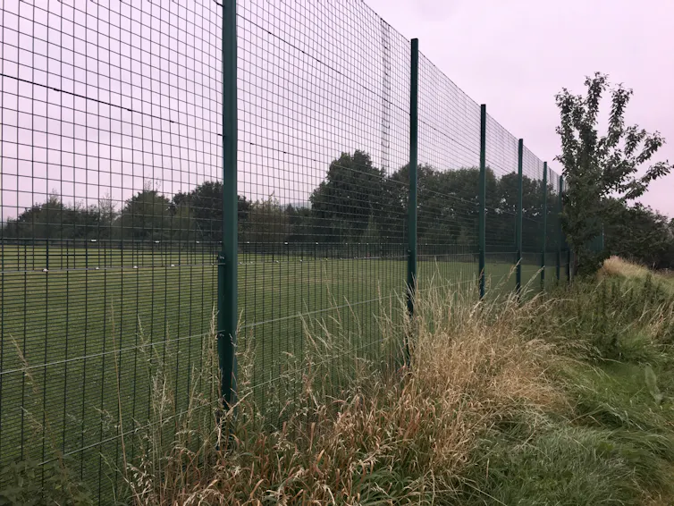 Chain link fence separating sports pitch