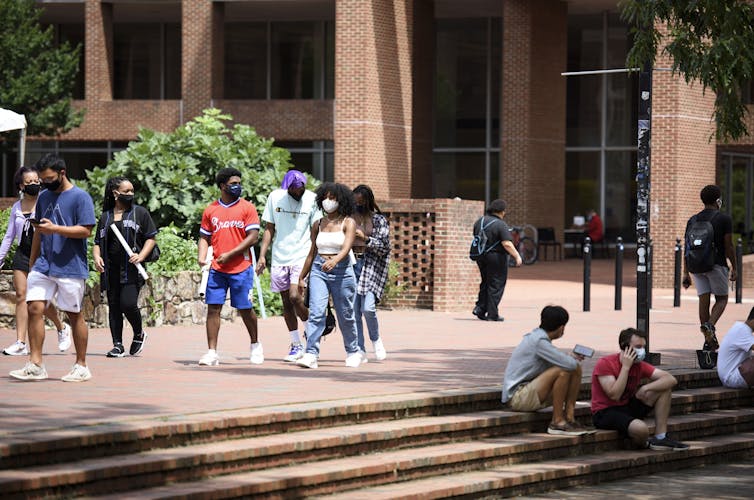 Students in masks walk on the University of North Carolina Chapel Hill campus.