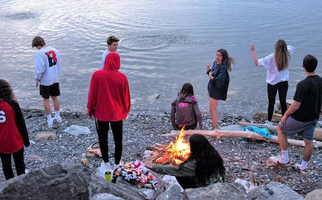 Teenagers meet around a campfire at Lake Champlain.