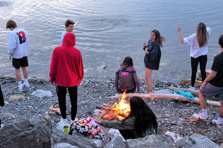 Teenagers meet around a campfire at Lake Champlain.