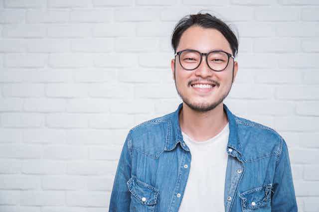 Young Asian man wearing glasses.