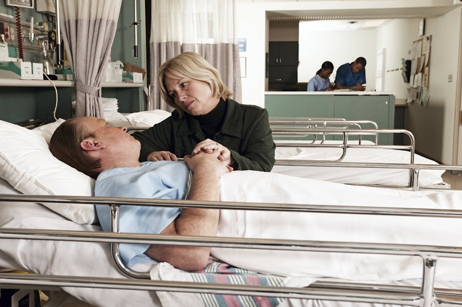 Women at the hospital bedside of husband.