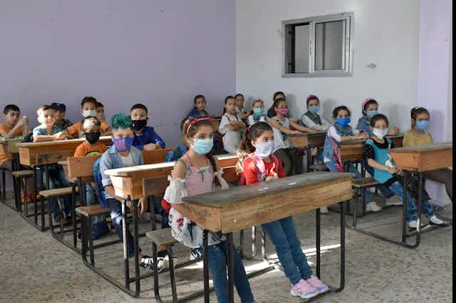 Syrian children wearing face masks in a classroom