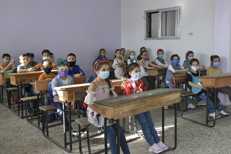 Syrian children wearing face masks in a classroom