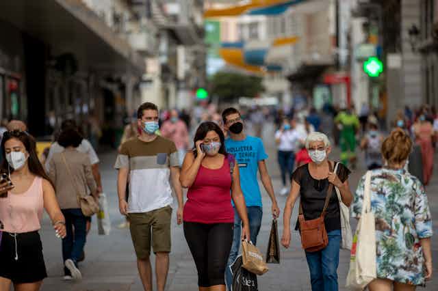 People wearing face masks while walking city streets
