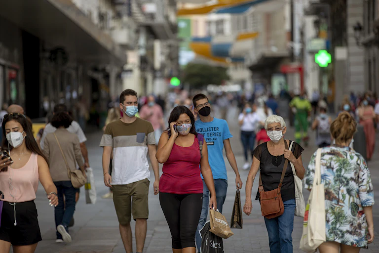 People wearing face masks while walking city streets